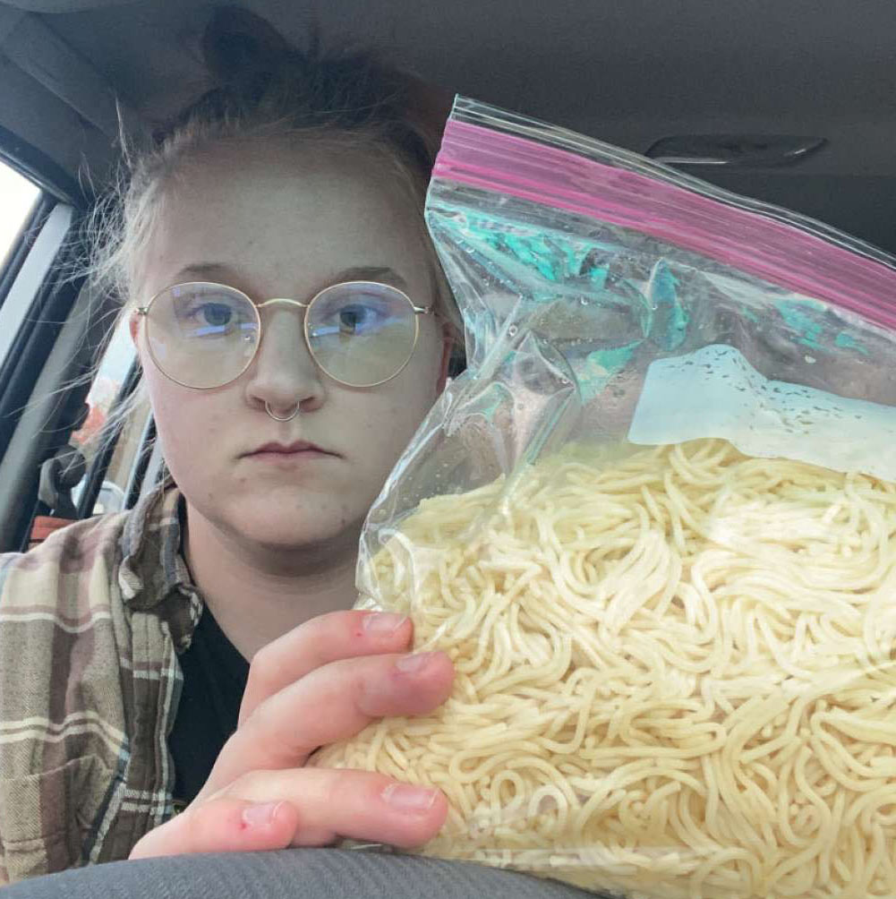 girl in a car holding a giant bag of spaghetti